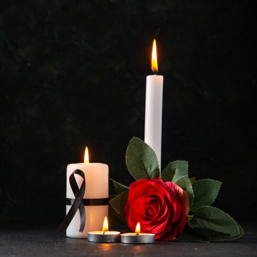 front-view-burning-candles-with-red-flower-dark-surface
